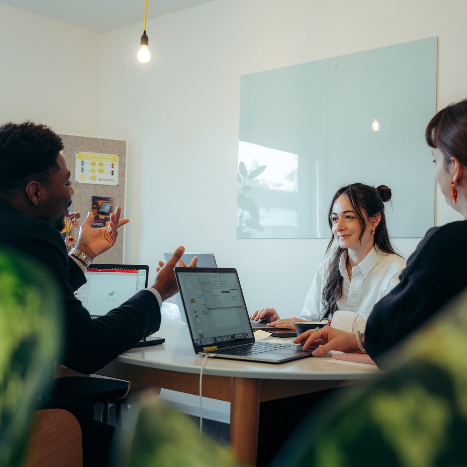 Anorac Studio, agence de communication à Fribourg : l'équipe en réunion de travail autour d'une table, ordinateurs portables ouverts